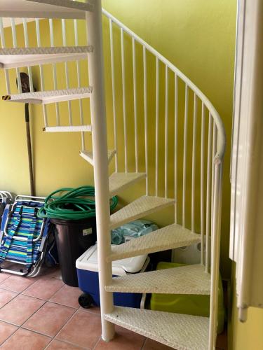 a white staircase in a room with a green wall at Beach Front Penthouse in Loiza