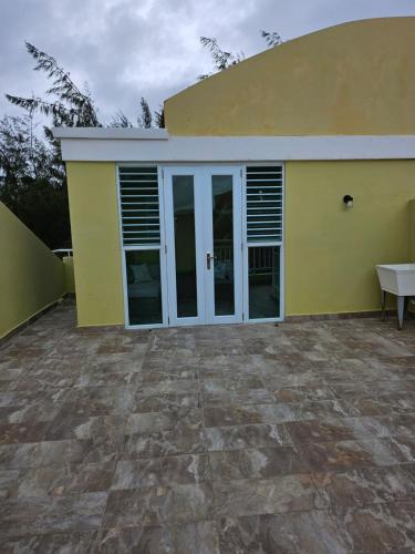 a yellow house with a patio in front of it at Beach Front Penthouse in Loiza