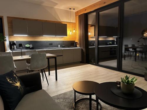 a kitchen and living room with a couch and a table at Loft N 39 - ekskluzywny apartament pod Zamkiem w Mosznej in Moszna