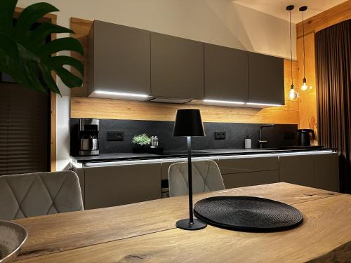 a table with a lamp on top of a kitchen at Loft N 39 - ekskluzywny apartament pod Zamkiem w Mosznej in Moszna