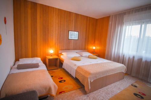 a hotel room with two beds and a window at Apartment Miranda in Slatine
