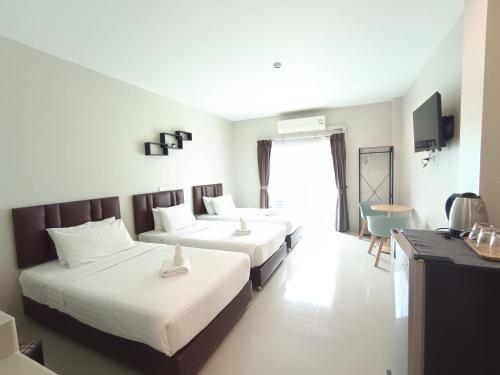 a hotel room with two beds and a television at Makan Resort in Kanchanaburi