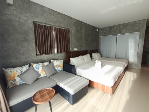 a bedroom with two beds and a couch at Makan Resort in Kanchanaburi