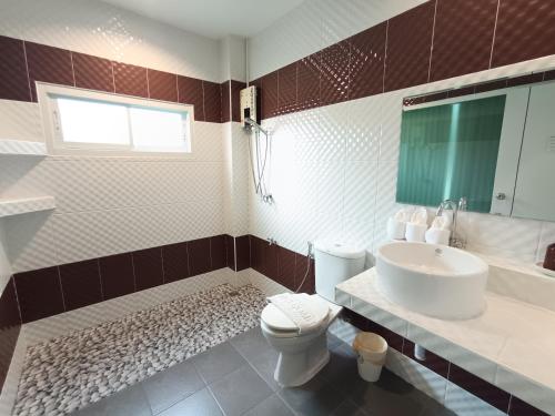 a bathroom with a white toilet and a sink at Makan Resort in Kanchanaburi