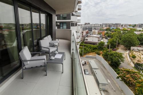 a balcony with chairs and a table on a building at SIA in Odyssey Pool & Spa Resort in Năvodari