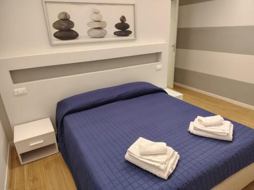 a bedroom with a blue bed with towels on it at Oasis Apartment - Pontassieve Guest House 2 - 20 minuti da Firenze in Pontassieve