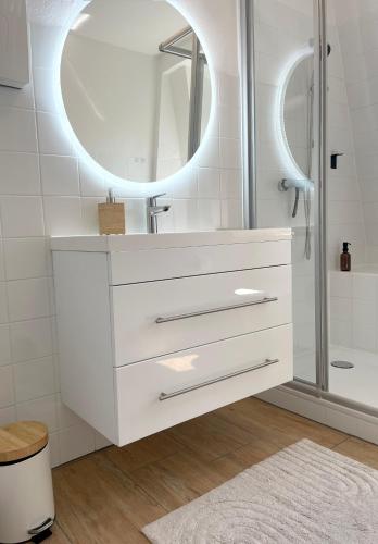a white bathroom with a sink and a mirror at Rooms 34 in Schweinfurt