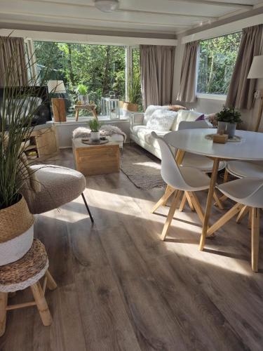a living room with a table and a couch at Sfeervolle woodlodge op 5 sterren vakantiepark in Raalte