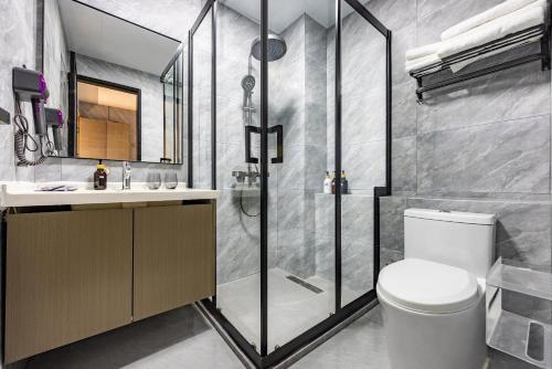 a bathroom with a shower and a toilet and a sink at Shanghai Zhuzhu Hotel - 24-hour free airport pick-up and drop-off at Pudong Airport in Shanghai