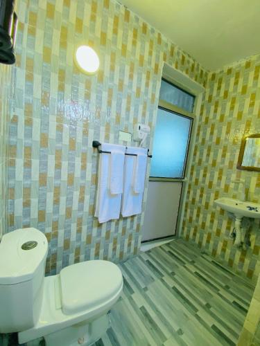 a bathroom with a toilet and a sink at Karibu House Paje in Paje