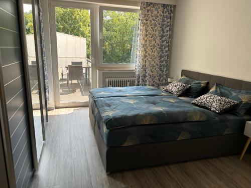 a bedroom with a bed and a large window at Stadtkern Apartment Bad Laasphe in Bad Laasphe