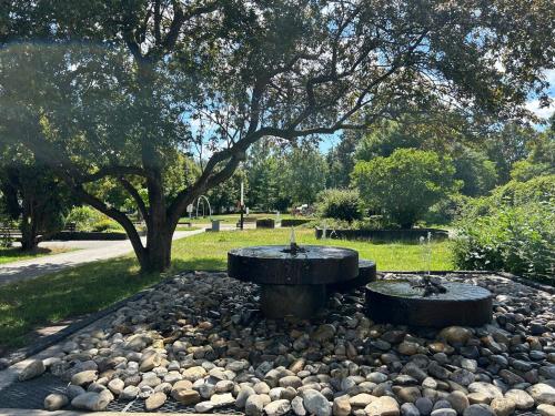 a fountain in a park with rocks and a tree at Stadtkern Apartment Bad Laasphe in Bad Laasphe