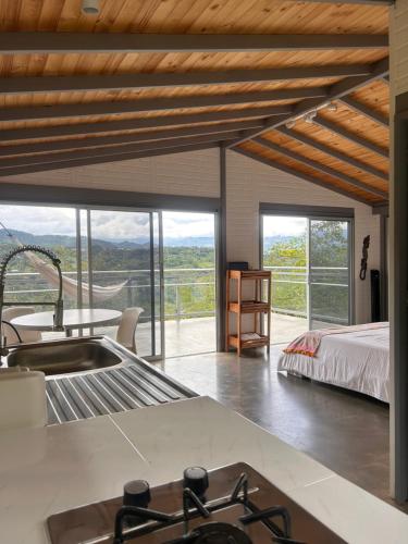 cocina con fregadero y dormitorio con cama en Entre Nubes, en Nocaima