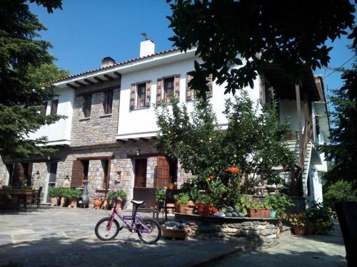 a pink bike parked in front of a building at Dimosthenis Karastamatis Rooms in Xorychti