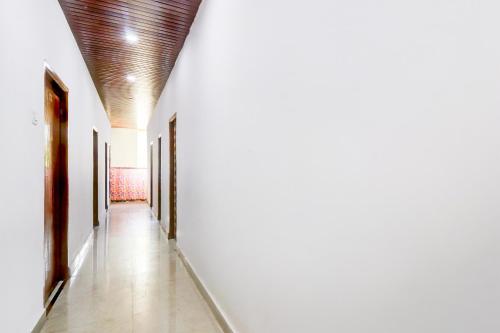 un pasillo con paredes blancas y techo de madera en Hotel O Tara Grand luxury Rooms, en Warangal