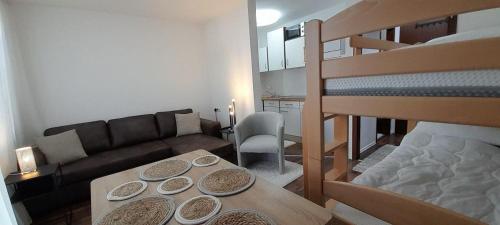 a living room with a table and a bunk bed at Casa Ludi Pforzheim Eutingen gute Wohngegend direkte Buchung möglich keine Freigabe erforderlich inklusive Balkon Terrasse und Tiefgaragenparkplatz im Haus in Eutingen