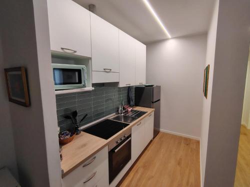 a kitchen with white cabinets and a sink and a microwave at Oasis Apartment - Pontassieve Guest House 2 - 20 minuti da Firenze in Pontassieve