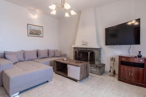 a living room with a couch and a fireplace at Kallisti's house in Mákri