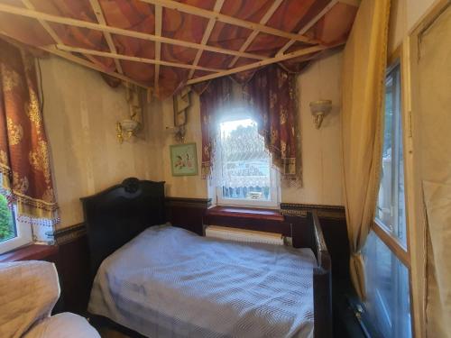 a small bedroom with a bed and a window at Baltā māja in Rīga