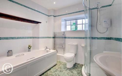 une salle de bain avec une baignoire, des toilettes et un lavabo dans l'établissement The Old Farmhouse, Yealand Redmayne, near Carnforth, à Beetham