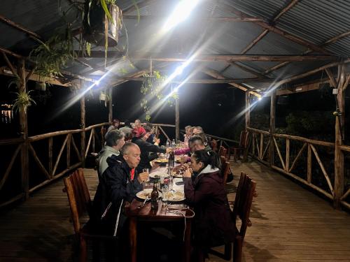 a group of people sitting at a table at a restaurant at Antique cottages in Kabale