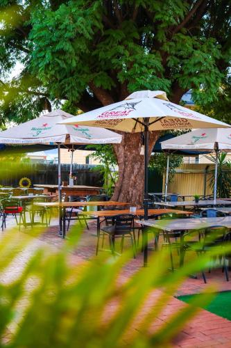 a group of tables with umbrellas in a park at The Piccadilly Hotel in Kalgoorlie