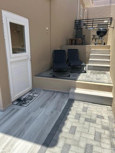 two chairs sitting on a porch next to a door at Ocean Breeze Apartment close to Mambo in Willemstad