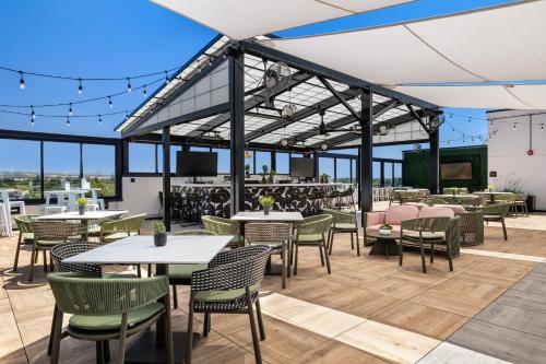 an outdoor patio with tables and chairs and a tv at Hotel Katerina in Chico