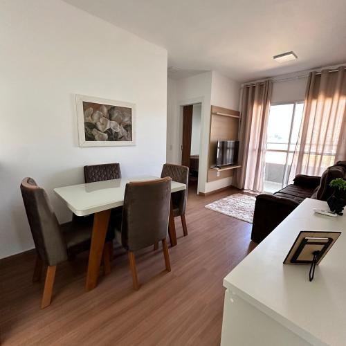 a living room with a table and chairs in a room at Estrela 04 Prime Loft in Extrema
