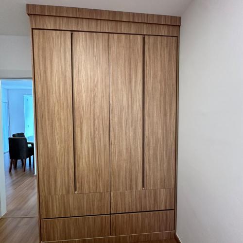 a large wooden closet in a room with a chair at Estrela 04 Prime Loft in Extrema
