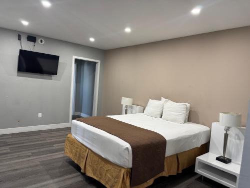 a bedroom with a bed and a flat screen tv at Holiday Lodge in Los Angeles