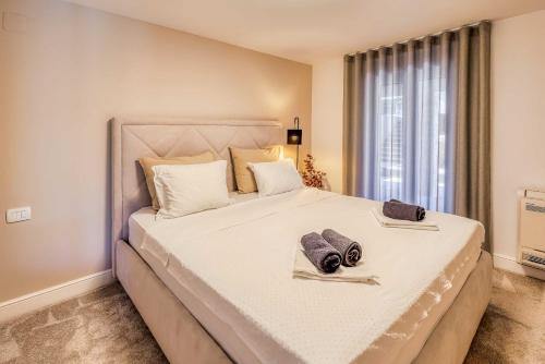 Un dormitorio con una gran cama blanca con toallas. en Apartment Siora, en Njivice