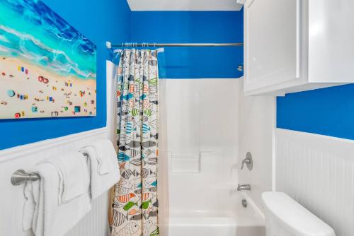 a bathroom with a shower curtain and a sink at Coconut Hut - Pet Friendly! Boardwalk to the Beach! - Pet Friendly! Boardwalk to the Beach! in Mustang Beach