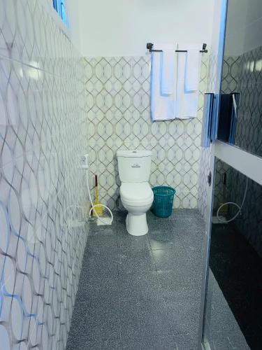 a bathroom with a white toilet in a room at Karibu House Paje in Paje