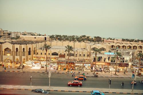 a city street with cars parked in front of a building at Town Hotel- Hurghada in Hurghada