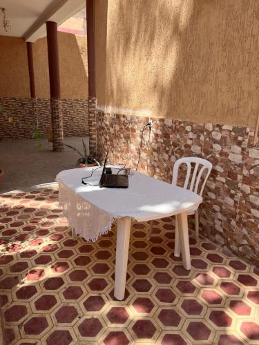 a table with a laptop sitting on top of it at Sunny City Villa with a Garden in Erfoud
