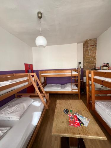 ベルリンにあるFreiraum Hostel Kreuzbergの二段ベッド3組とテーブルが備わる客室です。