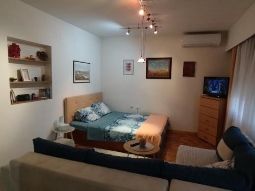 a living room with a bed and a couch at Fina Apartman in Leskovac
