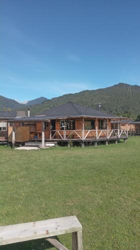 a log cabin with a bench in front of it at Patagonia Puelo Lodge in Cochamó