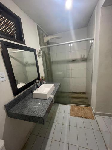 a bathroom with a sink and a shower at Brisa do Mar Cumuru - Pé na Areia in Prado
