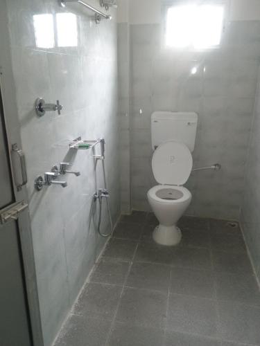 a bathroom with a toilet and a shower at Pranalay in Tezpur
