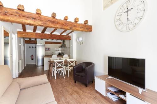 uma sala de estar com um sofá e um relógio na parede em Balcon del Encierro em Pamplona