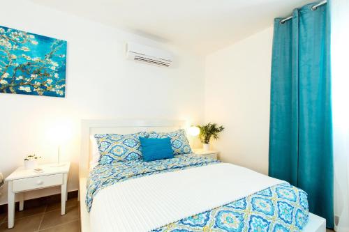 プンタ・カナにあるSANDY BAY SUITES DELUXE playa LOS CORALESの青と白のシーツが敷かれたベッドのある寝室