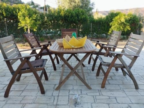 a wooden picnic table with chairs and a bowl on it at Villa Elaida in Ermioni