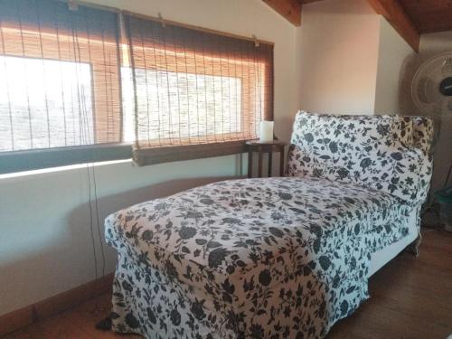 a bedroom with a bed and a chair and windows at Villa Elaida in Ermioni