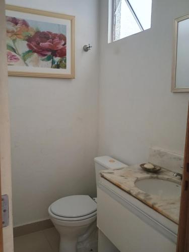 a bathroom with a white toilet and a sink at Casa para COP30 in Marituba