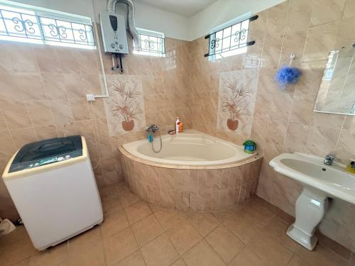 a bathroom with a large tub and a sink at Chez Shafah in Goodlands