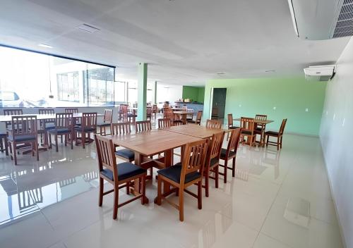 a dining room with a wooden table and chairs at Lençóis Prime Hotel in Barreirinhas