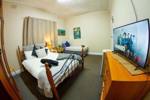 a bedroom with a bed and a flat screen tv at The Piccadilly Hotel in Kalgoorlie
