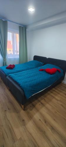 a large bed in a bedroom with a wooden floor at Studio Na náměstí in Potštát